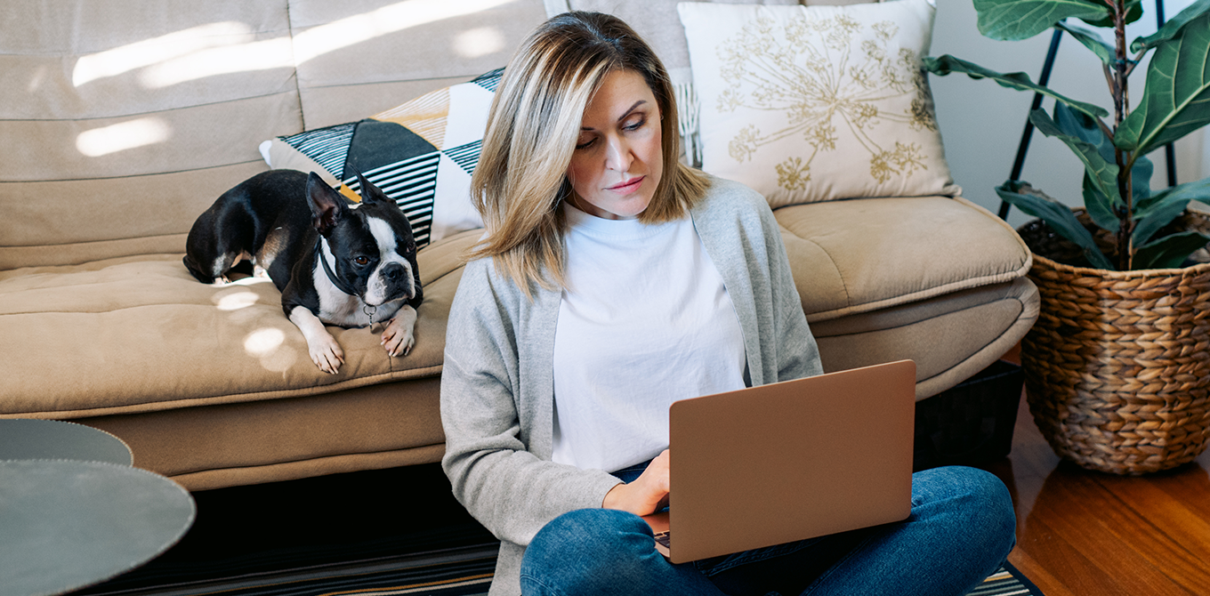 a woman sitting on the couch with her laptop