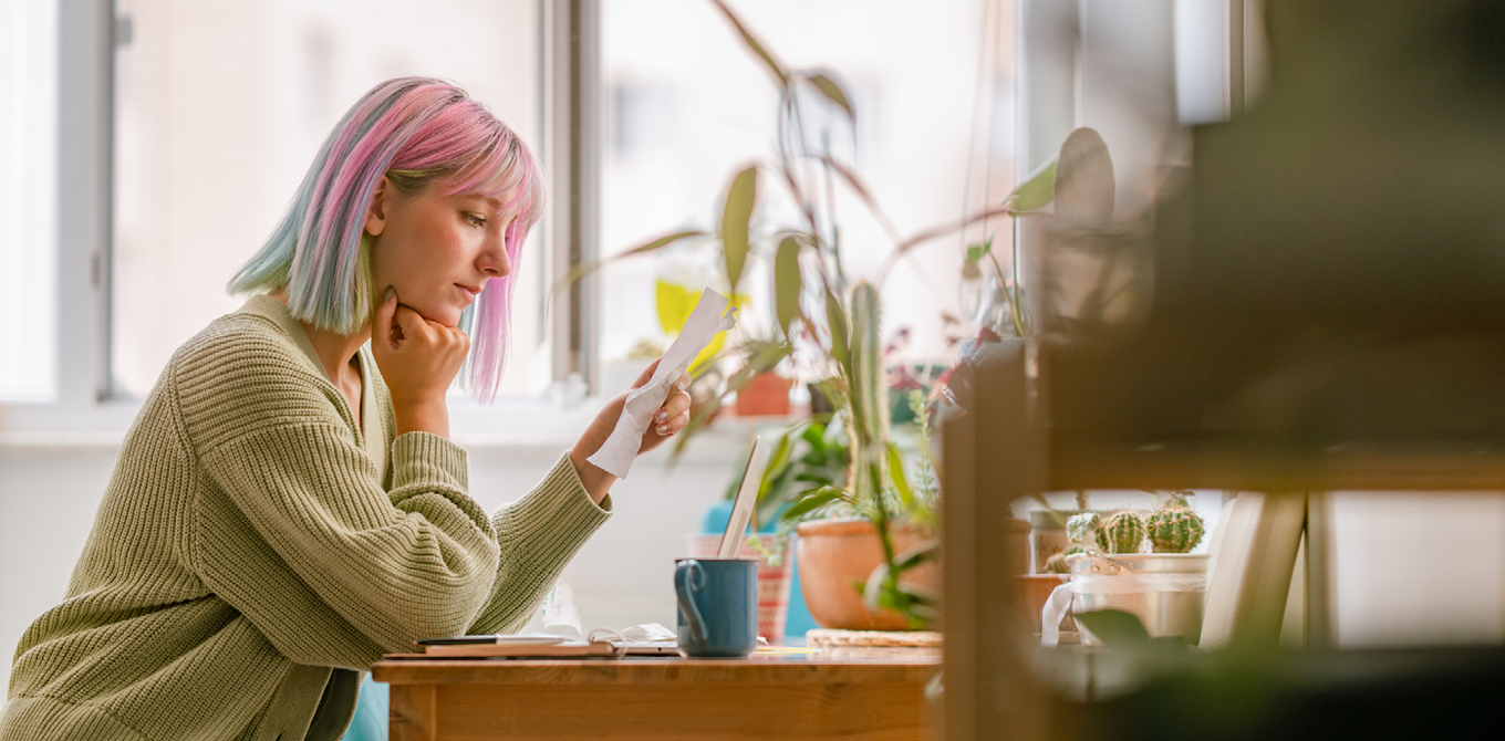 young woman looking at bills